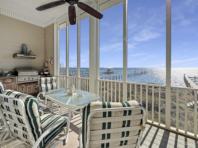 sunroom / solarium with a water view, a healthy amount of sunlight, and a ceiling fan