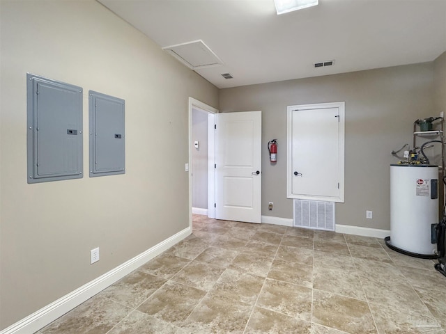 unfurnished room featuring electric panel, water heater, and visible vents