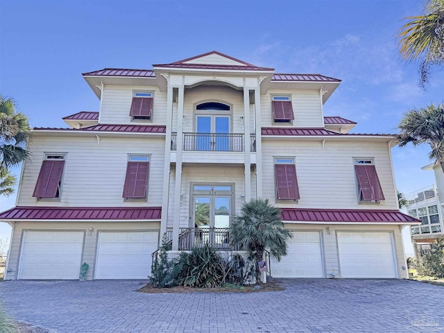 view of front of property featuring metal roof, french doors, a standing seam roof, and a balcony