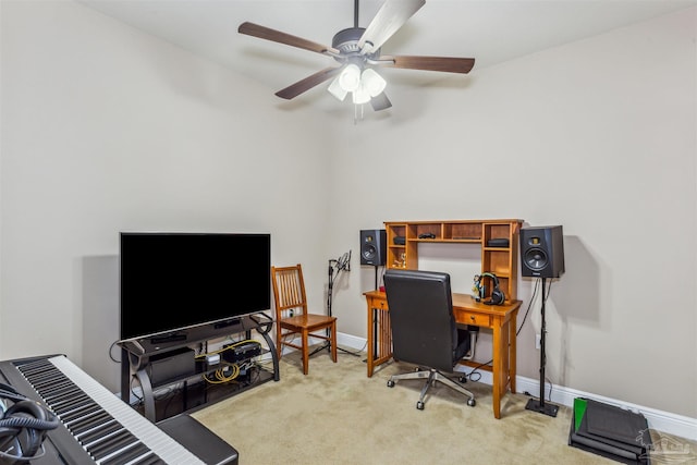 office space featuring a ceiling fan, light colored carpet, and baseboards