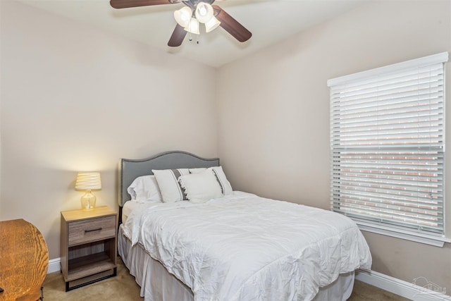 bedroom featuring light colored carpet, a ceiling fan, and baseboards