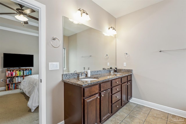 bathroom featuring double vanity, baseboards, and a sink