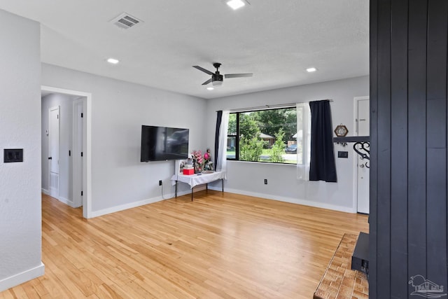 unfurnished living room with light hardwood / wood-style flooring and ceiling fan