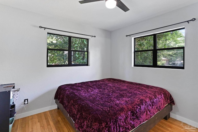 bedroom with light hardwood / wood-style floors, multiple windows, and ceiling fan