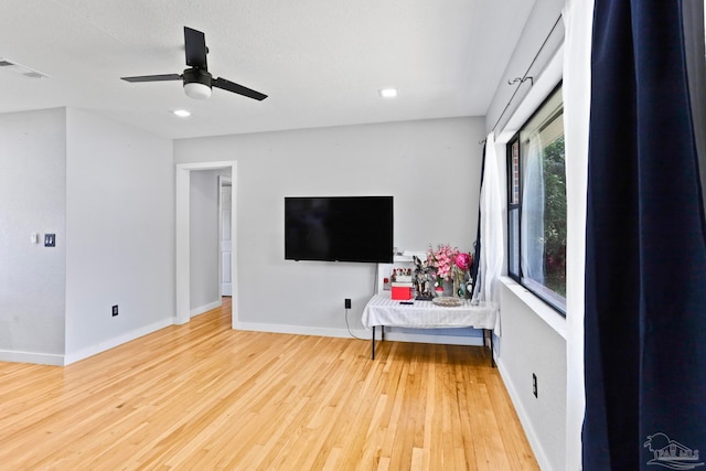 living room featuring wood-type flooring and ceiling fan