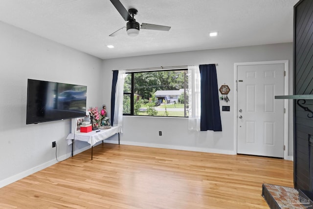 living room featuring light hardwood / wood-style floors and ceiling fan