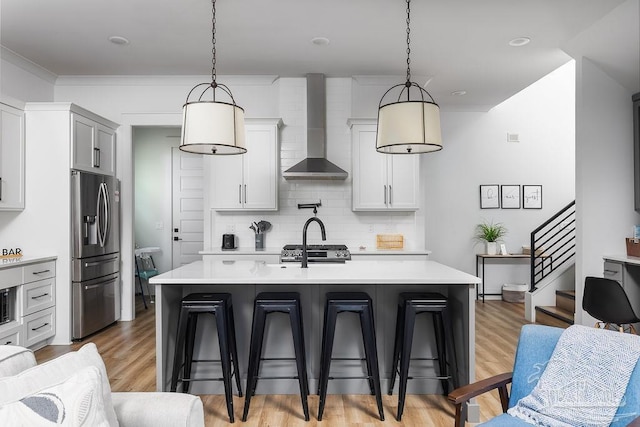 5611 Trout Ln, Pensacola, FL 32507 - kitchen featuring stainless steel appliances, wall chimney exhaust hood, a breakfast bar area, and light countertops