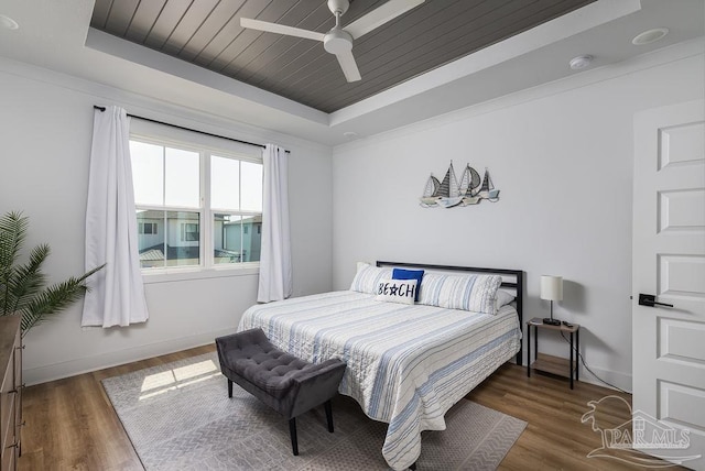 5611 Trout Ln, Pensacola, FL 32507 - bedroom featuring a raised ceiling, wood finished floors, baseboards, ceiling fan, and wood ceiling