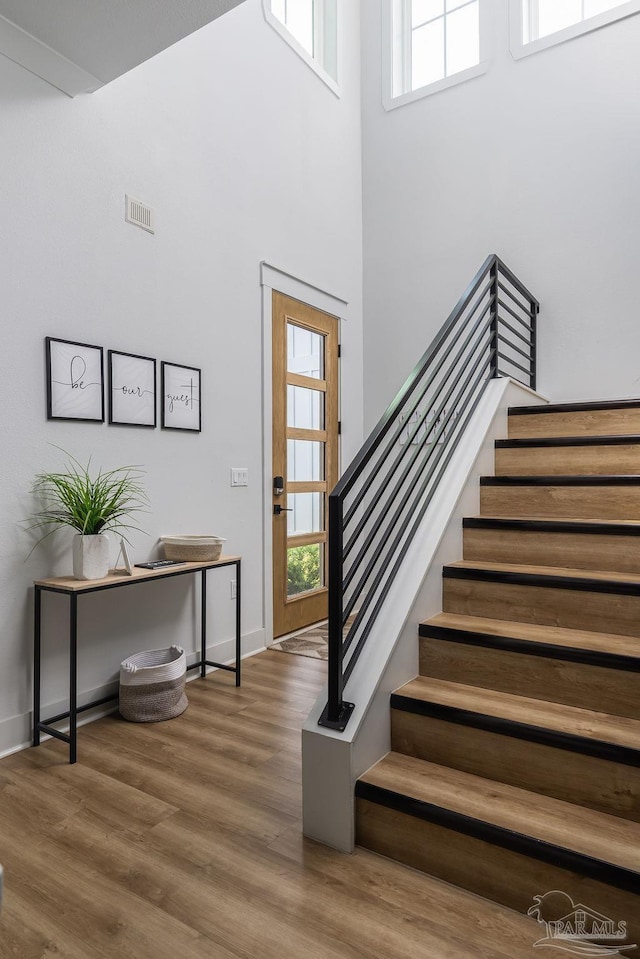 5611 Trout Ln, Pensacola, FL 32507 - staircase featuring wood finished floors, baseboards, and a high ceiling