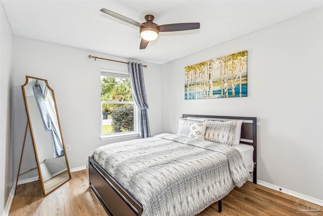 bedroom with ceiling fan, baseboards, and wood finished floors