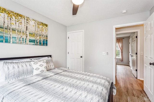 bedroom with a ceiling fan, baseboards, and wood finished floors