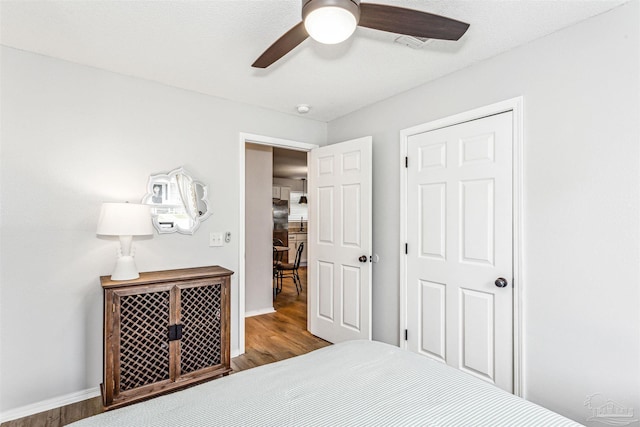 bedroom with baseboards, visible vents, ceiling fan, and wood finished floors