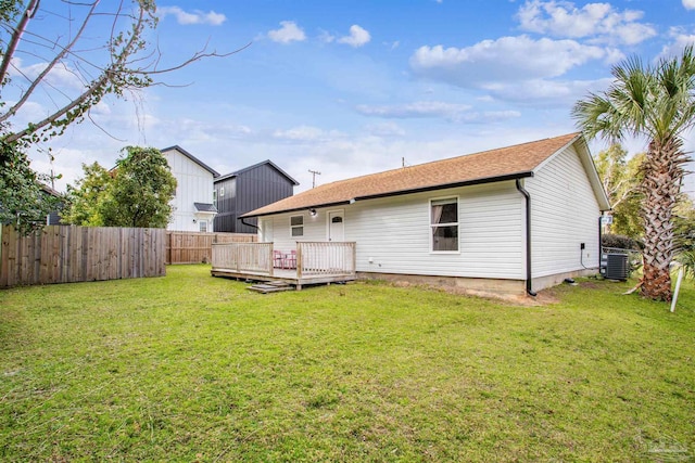 back of property with a fenced backyard, central AC unit, a wooden deck, and a yard