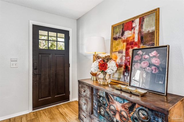 foyer with baseboards and wood finished floors