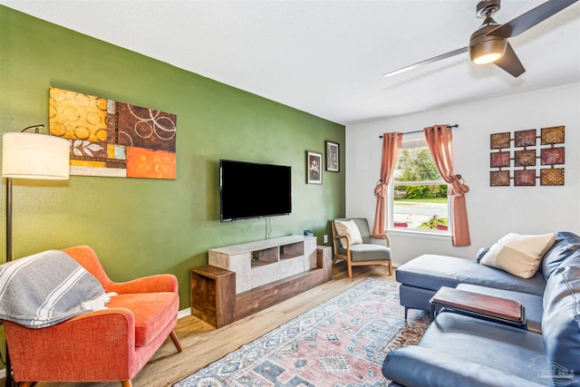 living area with ceiling fan and wood finished floors