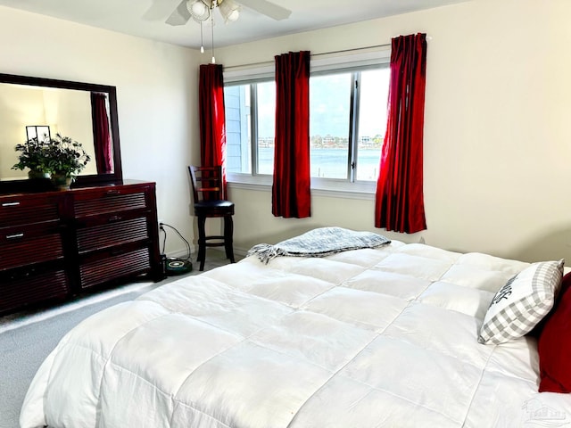 carpeted bedroom with a water view and ceiling fan