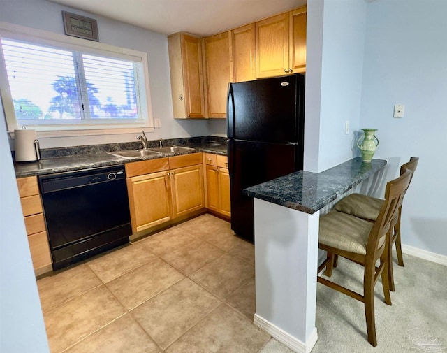 kitchen featuring black appliances, sink, a kitchen breakfast bar, light tile patterned floors, and kitchen peninsula