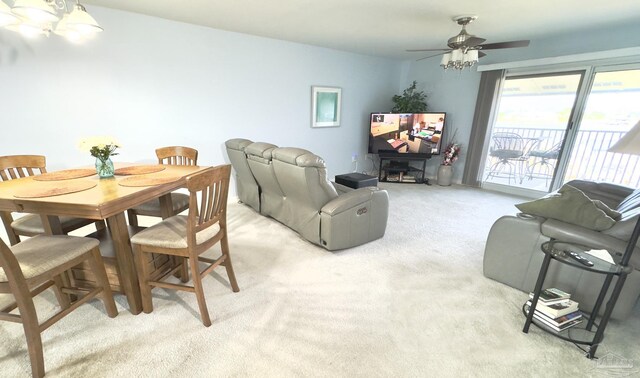 dining space featuring ceiling fan and light carpet