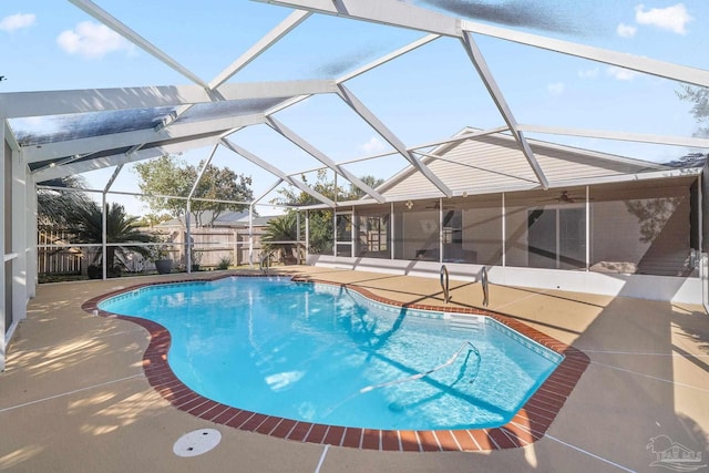 view of swimming pool featuring glass enclosure and a patio