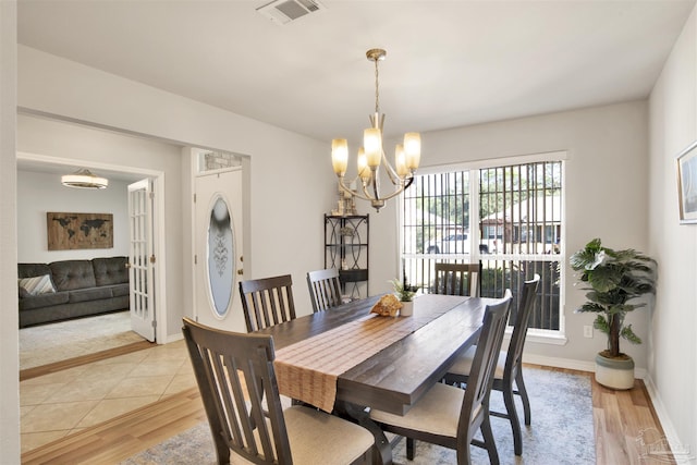 dining area with a chandelier and light wood-type flooring