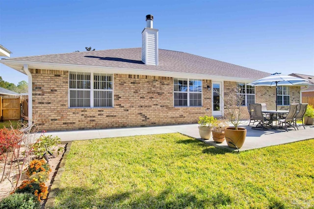 rear view of house with a lawn and a patio