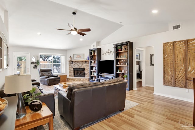 living room featuring ceiling fan, vaulted ceiling, a fireplace, and hardwood / wood-style floors