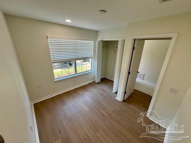 unfurnished bedroom with baseboards and wood finished floors