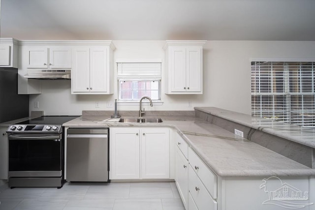 kitchen featuring a peninsula, a sink, stainless steel appliances, under cabinet range hood, and white cabinetry