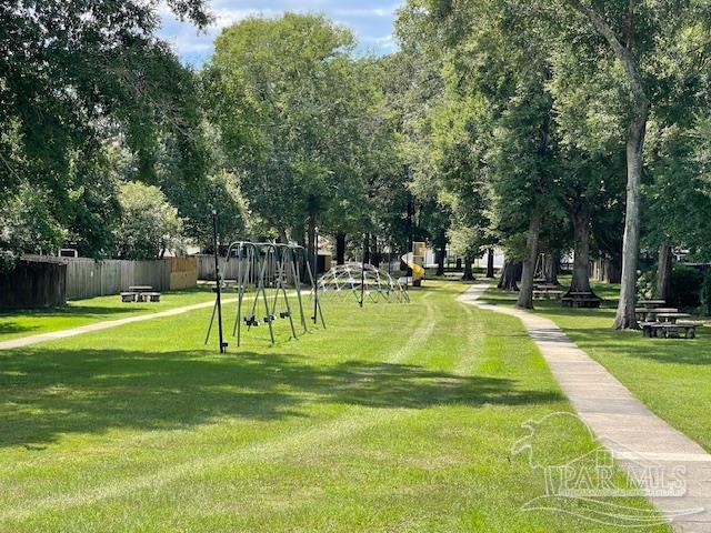 view of community with a lawn and fence