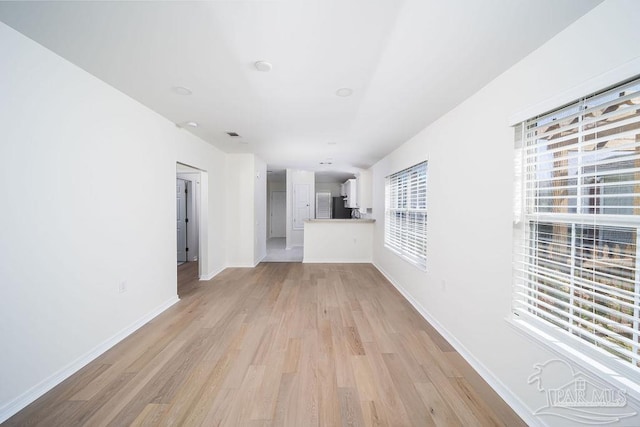 unfurnished living room featuring light wood-style flooring and baseboards