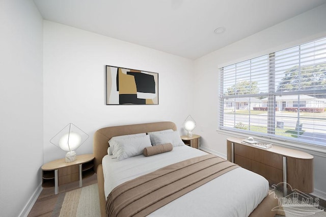 bedroom with baseboards and wood finished floors