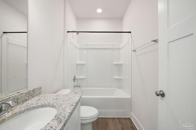 full bathroom featuring vanity, hardwood / wood-style flooring, toilet, and washtub / shower combination