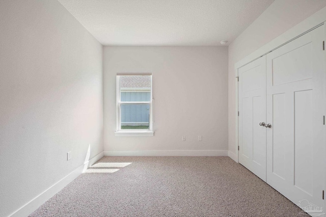 unfurnished bedroom featuring carpet and a textured ceiling