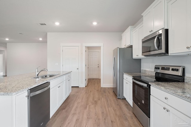 kitchen featuring sink, light hardwood / wood-style flooring, an island with sink, stainless steel appliances, and white cabinets