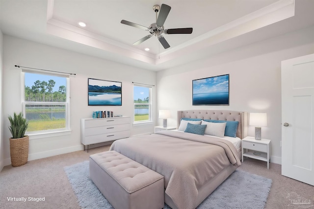 carpeted bedroom featuring a raised ceiling and ceiling fan