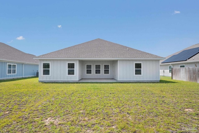 rear view of property featuring a lawn