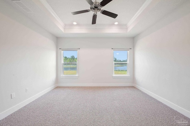 unfurnished room with ceiling fan, ornamental molding, a raised ceiling, and a textured ceiling