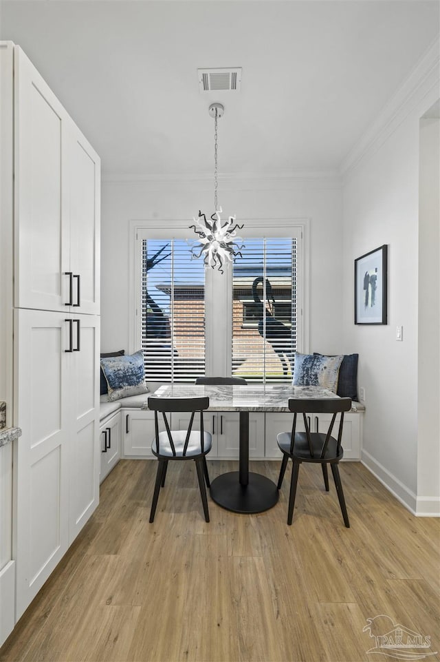 dining area with plenty of natural light, ornamental molding, and light wood-type flooring