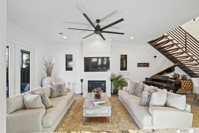 living room featuring hardwood / wood-style flooring, ceiling fan, and ornamental molding