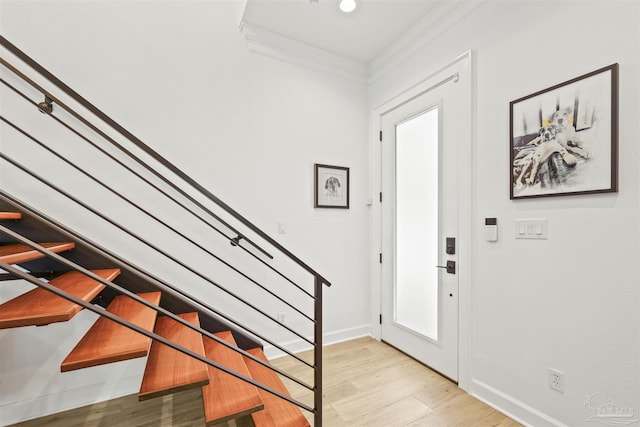 foyer featuring ornamental molding and light hardwood / wood-style floors