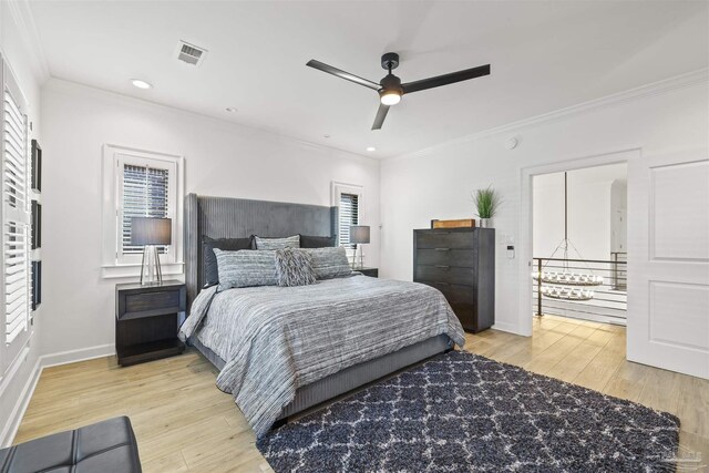 bedroom featuring ceiling fan, multiple windows, ornamental molding, and light hardwood / wood-style flooring