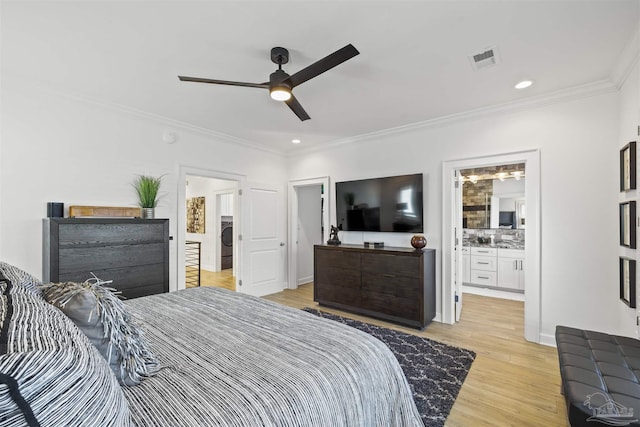 bedroom featuring washer / clothes dryer, ornamental molding, ceiling fan, ensuite bath, and light hardwood / wood-style flooring