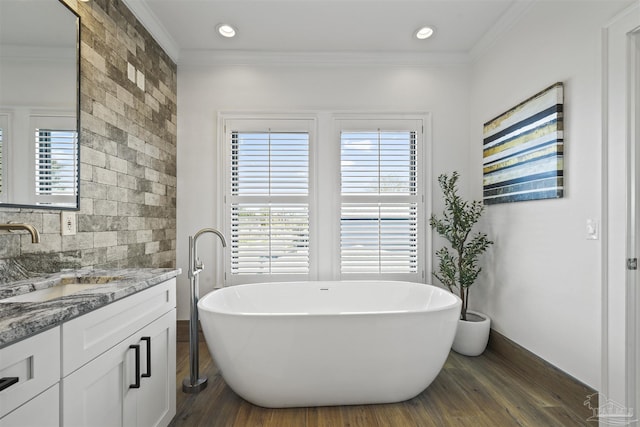 bathroom featuring hardwood / wood-style flooring, ornamental molding, plenty of natural light, and a bath