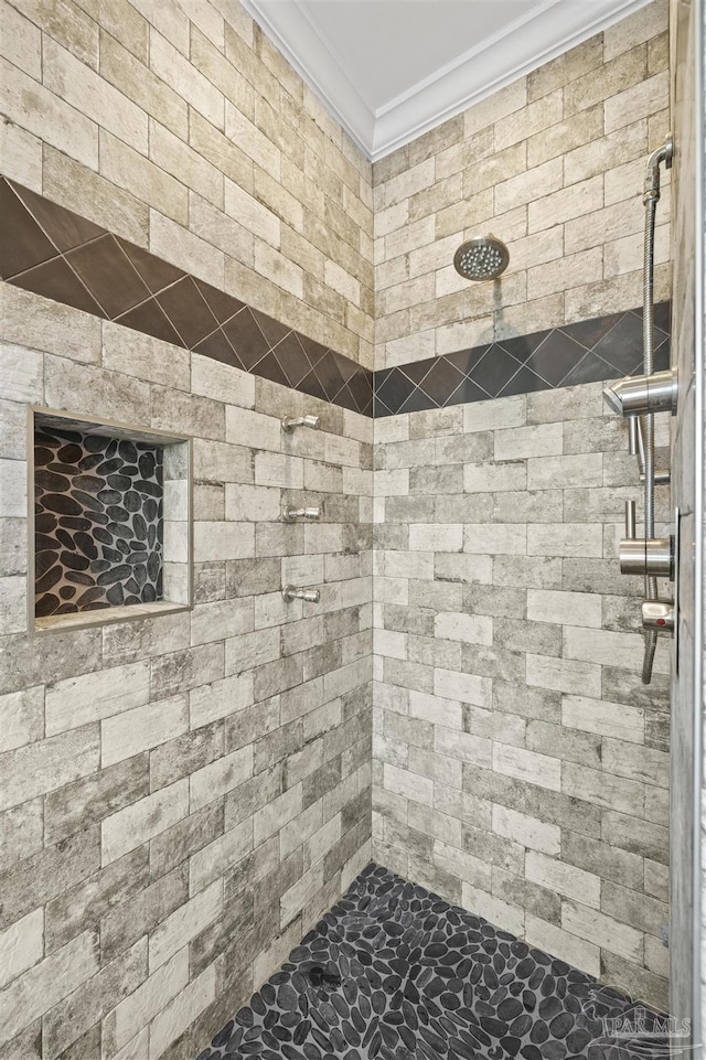 bathroom featuring crown molding and tiled shower