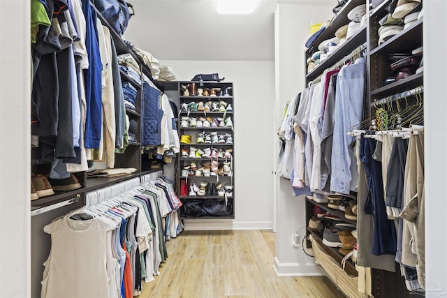 walk in closet with light hardwood / wood-style floors