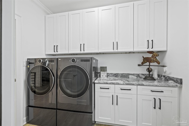 laundry room featuring ornamental molding, cabinets, and washing machine and clothes dryer