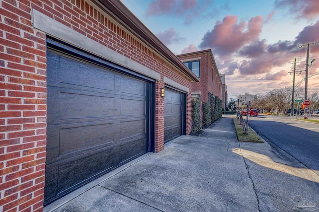 view of garage at dusk