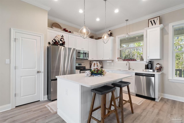 kitchen with white cabinetry, a center island, light hardwood / wood-style flooring, and appliances with stainless steel finishes