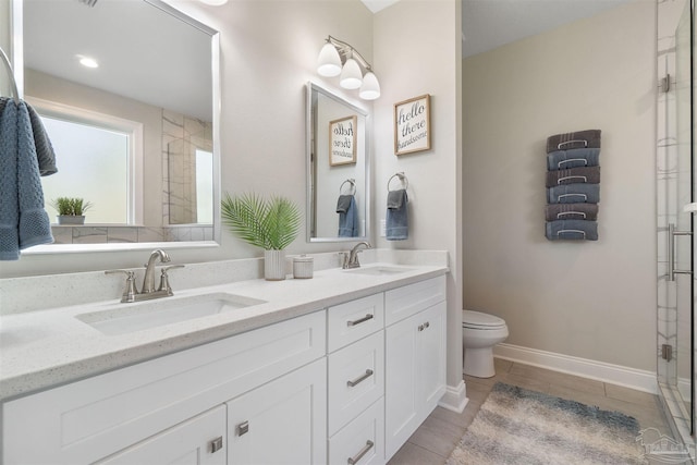 bathroom featuring tile patterned floors, vanity, toilet, and a shower with door