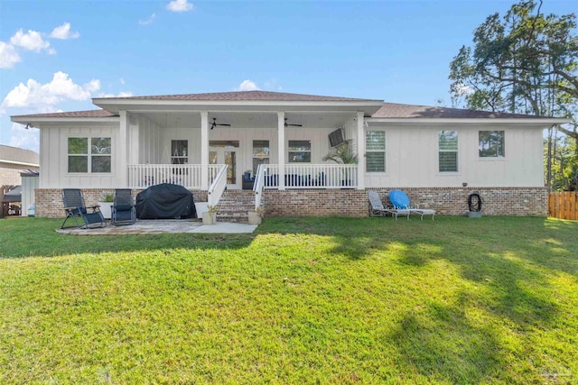 back of property featuring a lawn, ceiling fan, and covered porch